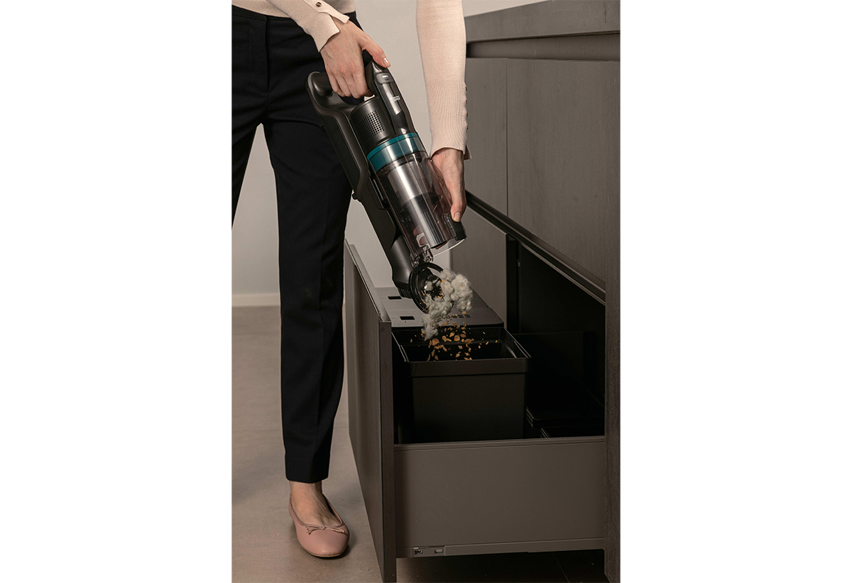 Μια γυναίκα αδειάζει εύκολα τον κάδο της σκούπας.